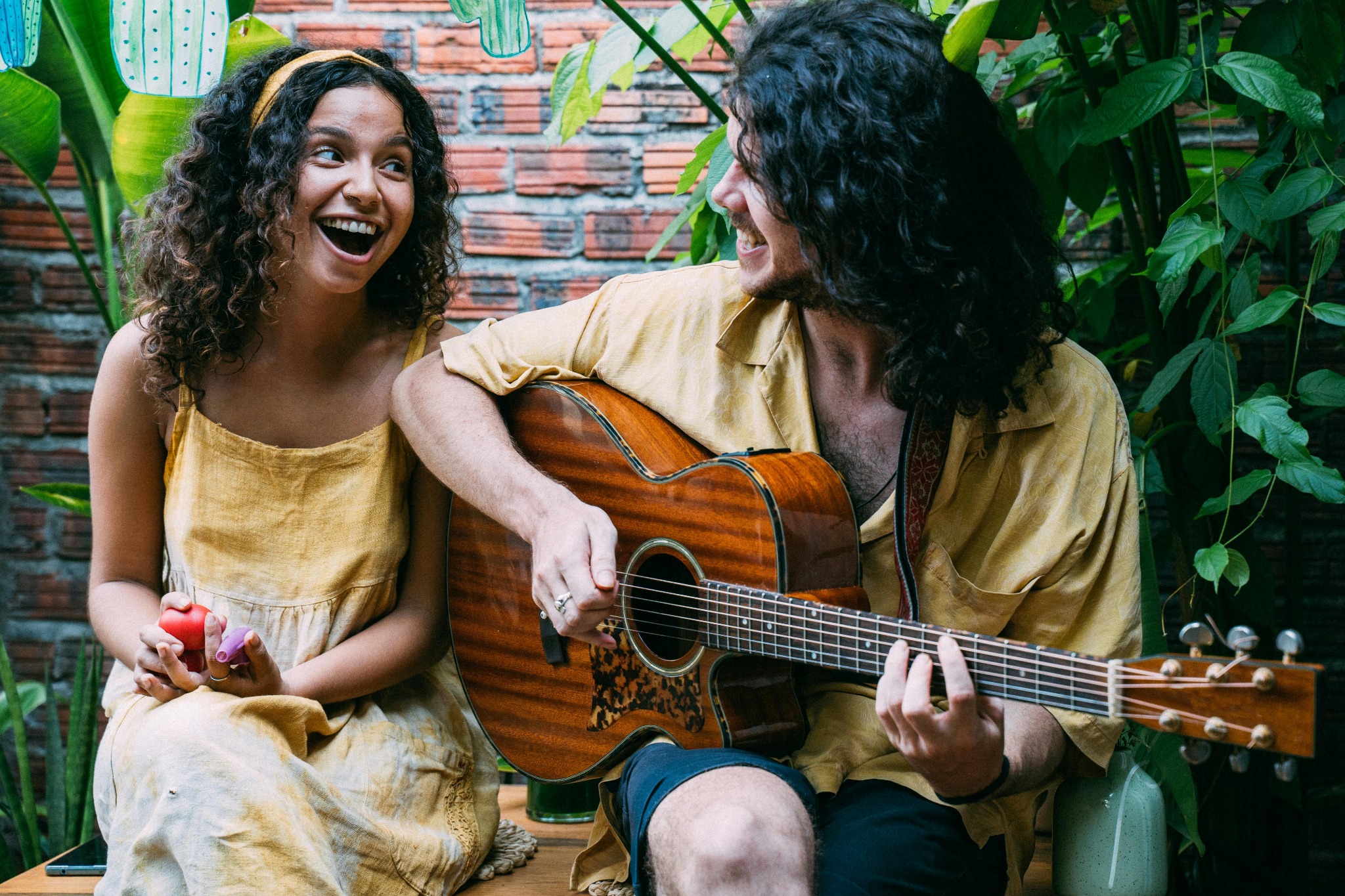 People smiling and playing guitar